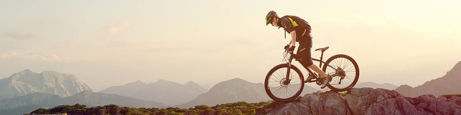 Ein Fahrradfahrer mit seinem Fahrrad in Bewegung auf einem Felsen.